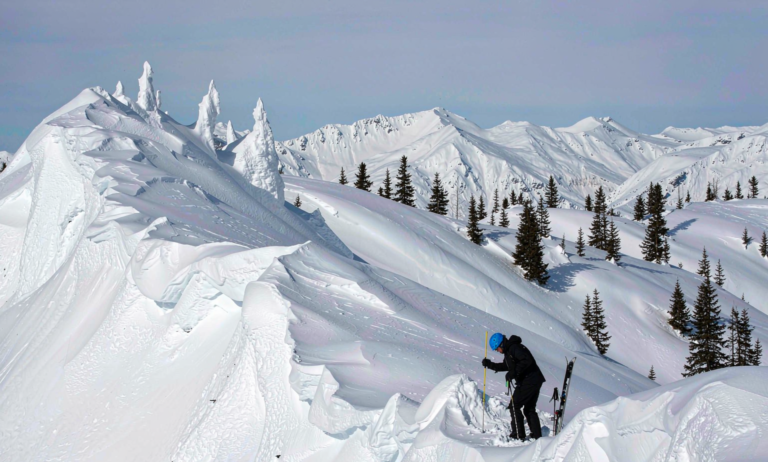 Backcountry skier probing snow with avalanche probe in Xinjiang