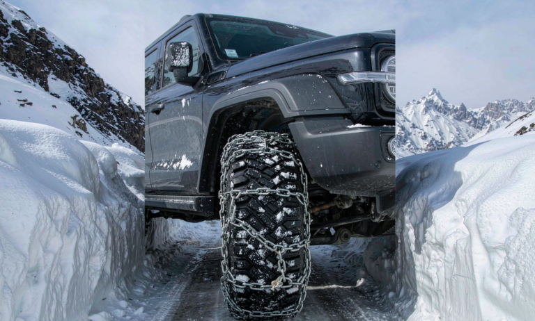 A car fitted with snow chains on a frozen Tianshan mountain pass in Xinjiang